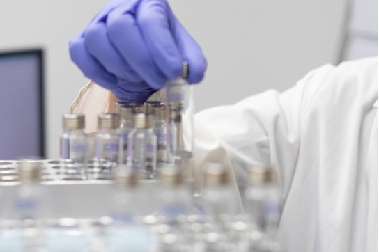 Mano con guantes cogiendo muestras en el laboratorio